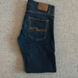 Mörkblå jeans från Nudie Jeans - Snygga mörkblå jeans från Nudie. Sitter super bra och är super schöna! Storlek 30w 32L. Hör av dig om du har några frågor!