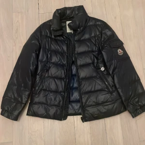 Moncler jacka - Jättesnygg Moncler jacka i barnstorlek L, dragkedjan är ersatt (se bild 4) och den saknar ”hängkrok” (bild 3). Köpt här på Plick och är för övrigt i mycket bra skick❤️ priset kan diskuteras!!