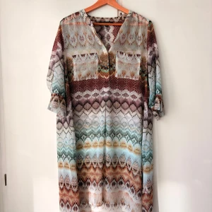 Mönstrad långklänning Ilse Jacobsen - Säljer en snygg långklänning från Ilse Jacobsen med färgstarkt mönster i vinrött, beige, blått och brunt. Klänningen har v-ringning, två bröstfickor och trekvartsärmar. Materialet är lätt och luftigt, perfekt för varma dagar.                                                 Köpt för 1400kr