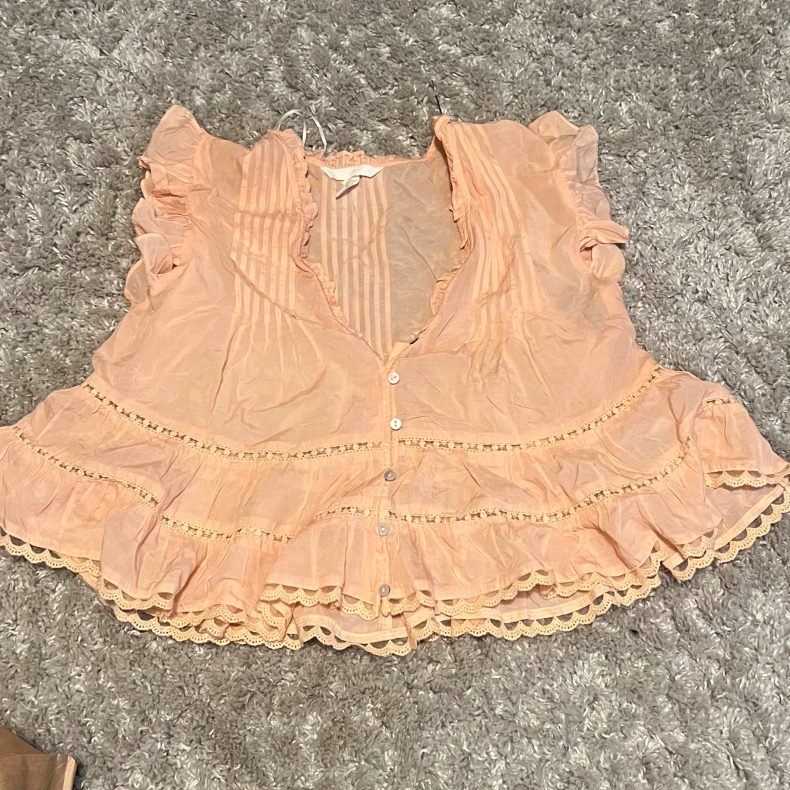 Persikofärgad blus med volangdetaljer