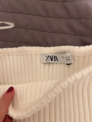 Ribbad vit tubtopp från Zara - Supersnygg ribbad tubtopp från Zara i vit färg. Toppen är axelbandslös med bandeau-modell och har en croppad passform.  använd 1 gång!