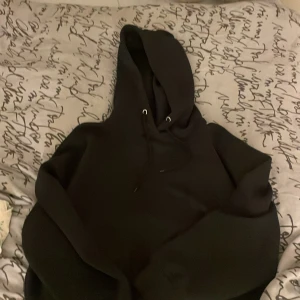 Svart hoodie från 157 med huva - Svart hoodie från 157 i storlek M. Klassisk modell med huva och snörning, perfekt för chill dagar. Mjuk bomullskänsla och rymlig passform. Snygg och enkel att matcha med jeans eller joggers.