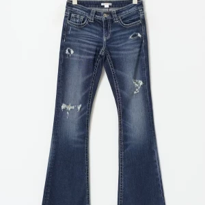 Blå bootcut jeans med slitningar - Snygga blå jeans med bootcut passform och slitna detaljer på benen. Jeansen har låg midja, klassiska fickor fram och bak samt kontrastsömmar. Jag är 165 och de sitter perfekt på mig!