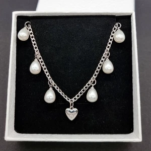 Stilfullt halsband  - Stilfull halskedja med hjärta och pärlor. Material: rostfrit stål. Längd: 40-45 cm. Kedjetjocklek-3mm Nickelfri. Priset utan ask blir lägre.