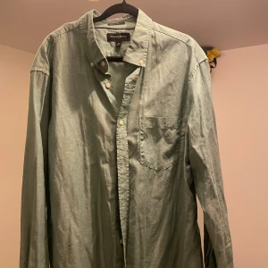 Skjorta från Banana Republic - Snygg grön skjorta från Banana Republic i storlek XL. Modellen är 'Untucked Fit' med klassisk krage, bröstficka och knappar framtill.
