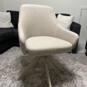 Matstol ROSTRUP vrid beige tyg  - Matstol med snurrfunktion – stilren, smidig och bekväm. Stolen kan enkelt vridas runt för bättre rörlighet vid bordet och extra bekvämlighet i vardagen. Den har en stabil konstruktion, mjuk sits och modern design som passar alla hem.                                                   HÄMTAS PÅ PLATS! 