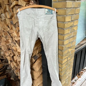 Beige jeans från Jacob Cohen, strl 32 - Snygga handgjorda jeans från Jacob Cohen i beige färg, modell Style 622. Klassisk femficksdesign med knappgylf och diskreta detaljer. Priset kan diskuteras. Säljes så de inte passar