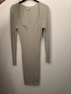 Beige ribbad långärmad klänning - Säljer en beige ribbad klänning med lång ärm och rundad urringning. Klänningen är kroppsnära och har en snygg, enkel design som passar perfekt för dig som gillar stilrena plagg. Materialet är stretchigt och bekvämt.