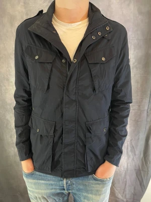 Woolrich Jacka  - Hej! Säljer nu denna väldigt snygga och eftertraktade Woolrich Fieldjacka! Jackan är slutsåld överallt och går inte att få tag på… Jackan är perfekt nu till vintern. Storlek L Skick: 9.5/10 Nypris: 6000 kr Säljs för: 1099 kr