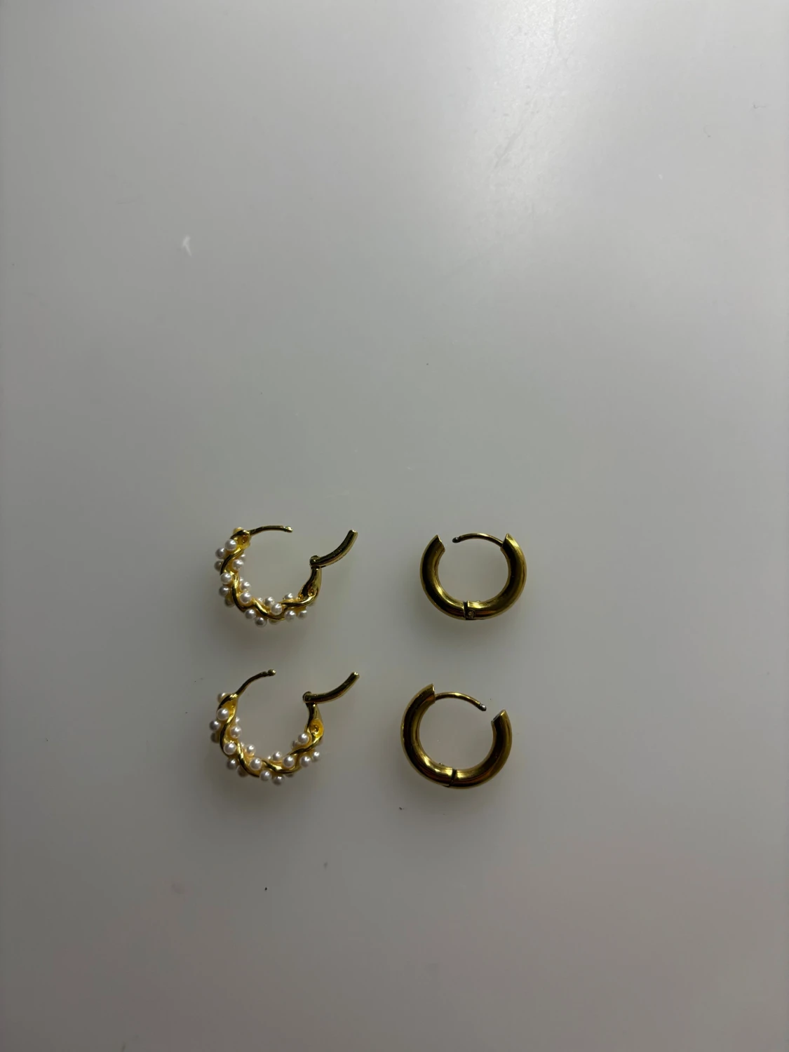 Två par guldfärgade örhängen