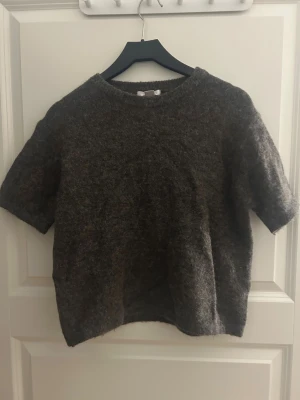 Mörkbrun stickad tröja med kort ärm - Mysig mörkbrun stickad tröja med rund hals och korta ärmar.☺️
