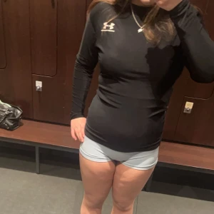 Svart långärmad träningströja från Under Armour - Säljer en svart långärmad träningströja från Under Armour med logga på bröstet. Tröjan har tight passform och är perfekt för gym eller löpning. Materialet är stretchigt och andas bra.