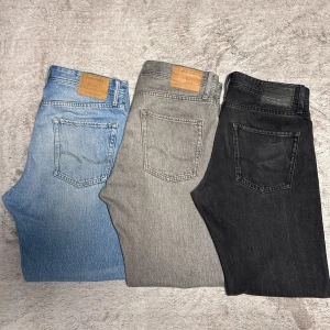 Jack & Jones jeans i tre färger - Tre par jeans från Jack & Jones, alla i stl 30/32. färgerna är ljusblå, grå och svart. Modellen är relaxed fit med klassisk femficksdesign och läderpatch bak i midjan. Jeansen är raka i benen och tillverkade i mjukt denimtyg. 3st-699kr/2st-349kr/ 1st-199kr. Pris kan diskuteras. 