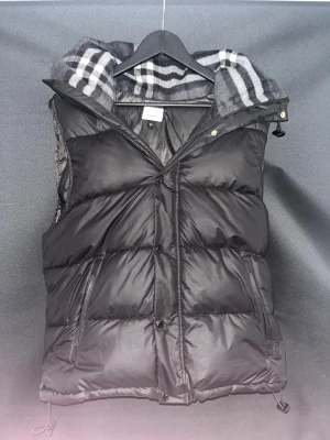 Burberry Jacka/Väst - Säljer nu min Burberry jacka som man kan göra om till väst, säljes på grund av att jag inte tyckte den passade. Använd väldigt fåtal gånger så nyskick. Har ej bild på armarna men dem fås såklart med. Kom privat för fler bilder/prisförslag