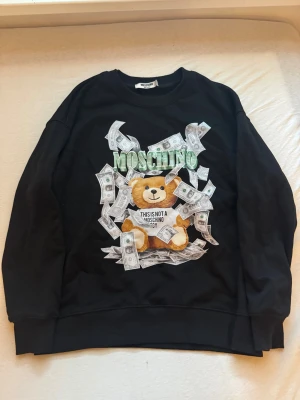 Moschino tröja - Svart dyr Moschino tröja inga skador förutom att lappen lossnat lite syns på bilden storlek M passar mycke mindre