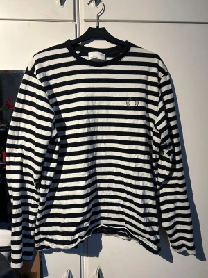 Randig långärmad tröja Selected Homme - Snygg långärmad tröja från Selected Homme i svart och vitt med klassiskt randigt mönster. Rund hals och diskret logga på bröstet. Tillverkad i mjuk bomull som känns skön mot huden. Perfekt för dig som gillar stilrena och tidlösa plagg.