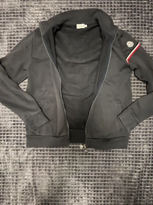 Moncler zip tröja  - Passar också M - Notera att tröjan är mörkblå men ser svartare ut på bilderna - enda defekten är att färgen på dragkedjan har försvunnit lite  ( se bild 5)