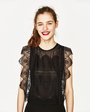 Svart spetsblus från Zara - Supersnygg svart blus från Zara Trafaluc med transparent mesh och detaljerad spets över hela toppen. Ärmlös modell med vågiga spetskanter och rund halsringning. 