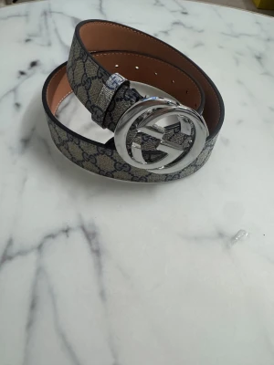 G bälte  - Säljer ett snygtt bälte för ett bra pris. Den är tillverkat i skinn med canvas-yttermaterial. Perfekt för dig som vill ha en ikonisk accessoar med lyxig känsla.