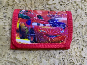 Barn plånbok med motiv - Två coola plånböcker med motiv från Cars och Paw Patrol. Ena plånboken är röd med Lightning McQueen och holografiska detaljer, den andra är blå med Paw Patrol-karaktärer och glittrigt mönster. Perfekt för att hålla koll på cash och kort, med praktisk kardborre och färgglad design. 55kr/st  . 3 år + 