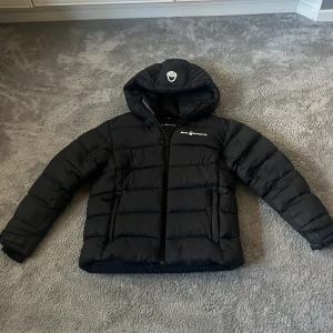 Svart pufferjacka från Sail Racing - Svart pufferjacka från Sail Racing med huva och dragkedja framtill. Jackan är sjukt snygg och väldigt varm, perfekt vinterjacka. Skick 7/10 nypris 2100kr säljs för 799kr pris kan diskuteras vid snabb affär. 