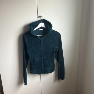 Mörkgrön velour hoodie XS - Mysig mörkgrön hoodie i velour från Cubus, med dragkedja framtill och fickor. Tröjan har luva och långa ärmar.  croppad passform. 