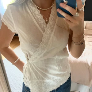 Vit omlottblus med spetsdetaljer - Söt omlott topp med knytning och detaljer i spets