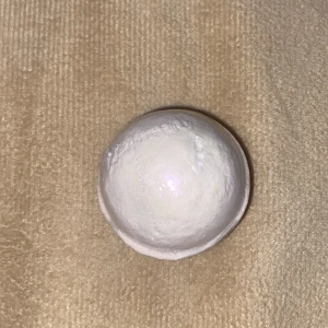 Vit rund bandbomb  - Säljer en vit, rund glittrig badbomb som man kan ha när man har hemma spa till sinna fötter eller lägga i sitt badkar. Har inte använt den här men jag testade en annan och vattnet blev glansig och det luktade gott. Perfekt för dig som gillar och ha hemma spa 🧖‍♀️💕