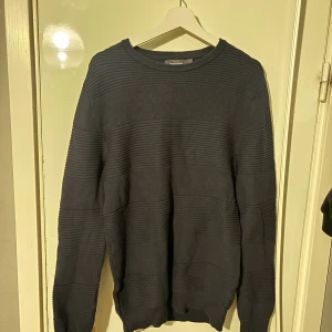 Stickad tröja - Stickad mörkblå tröja i storlek M, använts en gång.