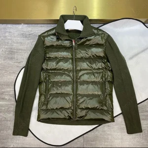 Olivgrön pufferjacka med stickade ärmar - Snygg olivgrön pufferjacka med glansig framsida och stickade ärmar. Jackan har dragkedja framtill och hög krage för extra stilpoäng. Perfekt för dig som vill ha en modern look med både värme och rörelsefrihet.