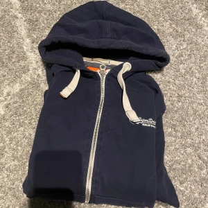 Superdry hoodie - En mörkblå Superdry hoodie i storlek L bra skick det är bara att skriva vid intresse eller vid frågor