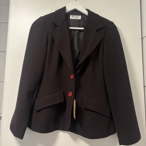 Brun Blazer - Säljer denna figursydda blazern då den är lite liten för mig. Storlek 34, samt lite kortare ärmar + axelvaddering. Köpt second hand/sellpy. Har själv aldrig använt den. Bra skick 💕