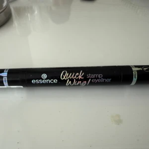 Essence Quick Wing! Stamp Eyeliner - Bara testat en gång! Dubbeländad svart eyeliner från Essence med en spetsig filtspets på ena sidan och en vinge-stämpel på andra. Perfekt för att snabbt skapa skarpa och symmetriska cat eyes. Pennan är svart och har en smidig design i plast.