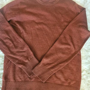 Rostbrun stickad tröja Bruun & Stengade - Säljer en rostbrun stickad tröja från Bruun & Stengade i storlek M. Tröjan har rund halsringning, långa ärmar och breda ribbade muddar. Materialet är en mix av 50% merinoull och 50% akryl, vilket gör den både mjuk och varm. Perfekt för kyligare dagar.