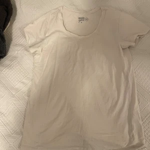 Vit basic t-shirt  - Enkel och stilren vit t-shirt i mjuk bomull. T-shirten har korta ärmar och rund halsringning, perfekt basplagg 