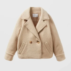 Beige skepparkavaj från Zara - Beige skepparkavaj från Zara med dubbelknäppning och stora kragar. Jackan har två snedställda fickor framtill och är tillverkad i ett mjukt, ull. Perfekt för dig som vill ha en klassisk och trendig look med lite oversized känsla.