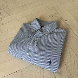 Ralph Lauren skjorta|Storlek M|Slim fit - Riktigt fin Blårandig Ralph Lauren skjorta storlek M slim fit. Pyttelite gul i nacken men absolut inget man tänker på. Kika gärna in mina andra plagg för bundles med rabatt!😊 Hör av er vid funderingar!😊🙏