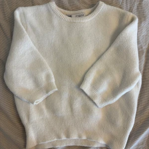 Vit stickad tröja från Zara - Mysig vit stickad tröja från Zara med rund halsringning och ribbade muddar. Tröjan har en enkel och clean look, perfekt för lager-på-lager och chill dagar. Passar dig som gillar en klassisk och stilren vibe.