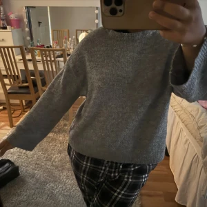 Grå stickad tröja med vida ärmar - Mysig grå stickad tröja med rund hals och vida, långa ärmar. Perfekt för lager-på-lager och chill dagar. Enkel och stilren design som funkar till det mesta. Skön och avslappnad passform.