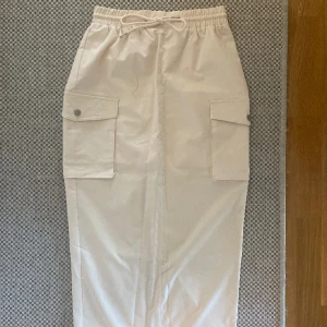 Cargokjol midikjol beige creme kjol - Snygg cargokjol med slits bak. Aldrig använd, storlek S. Köparen står för frakt.