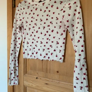 Blommig crop top  - Blommig crop top i mjuk bomull. I använt men fint skick. Storlek S. Längd 41cm Ärmlängd 50cm  Bredd 32cm (OBS mycket stretchig!)