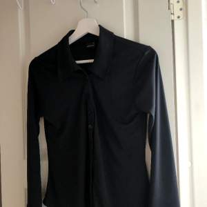 En svart blus som är lite skjortliknande i modellen men har ett väldigt mjukt och skönt material, den är knappt använd!😊🌟
