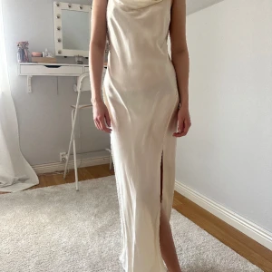 Créme färgad midi/långklänning - student eller bal - En créme/vit midi/lång klänning med slits perfekt till stundet eller bal. Storlek 38. Nyskick, använd ett fåtal gånger, normal storlek. Från & other stories, nypris 890kr.