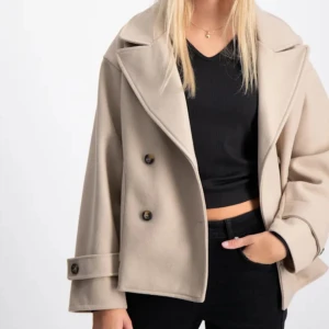Kort beige kappa från ryvls  - Säljer denna jättefina korta kappa från ryvls i modellen Stockholm peacoat. Jackan är aldrig använd och är i storlek 146/152. Passar xs/s. Pris kan diskuteras, nypris 699 kr.☺️☺️