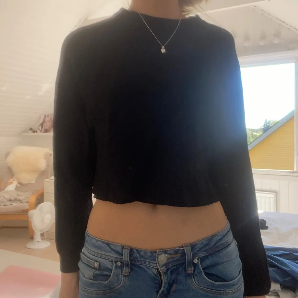 Säljer en snygg svart croppad tröja från Pull&Bear. Den är perfekt för både höst och vår med sin långärmade design. Tröjan är i nyskick och har en normal passform. Materialet känns mjukt och bekvämt, vilket gör den idealisk för vardagsbruk. Passar perfekt till ett par jeans eller kjol!. Tröjor & Koftor.