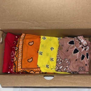 Färgglada halsdukar i olika mönster - Säljer ett set med fyra färgglada bandanas i olika mönster. En röd, en orange, en gul och en smutsrosa   Perfekta för att liva upp din outfit!