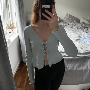 kofta - ljusblå, långärmad, tunn, topp med snörning framtill, så kan även användas som en ”kofta”. aldrig använd☺️