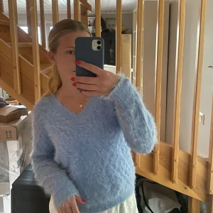 Stickad tröja - Säljer en blå jättemysig stickad tröja. Superskön, har ett litet hål som syns på bild 2 men går lätt att dra och fixa till som jag gjort på bild 3 och då tänker man inte alls på det.