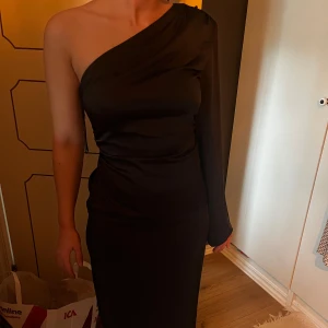 Svart One-shoulder klänning - Svart satinklänninh med en arm. Använd 1 gång. Perfekt till fest. Skriv vid fler bilder eller intresse🖤