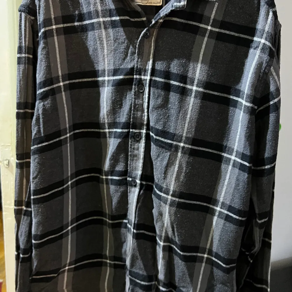 Rutig svart/grå flannelskjorta från these glory days i storlek L. Jättefint skick. Två extra knappar medföljes. Normal i storleken . Skjortor.